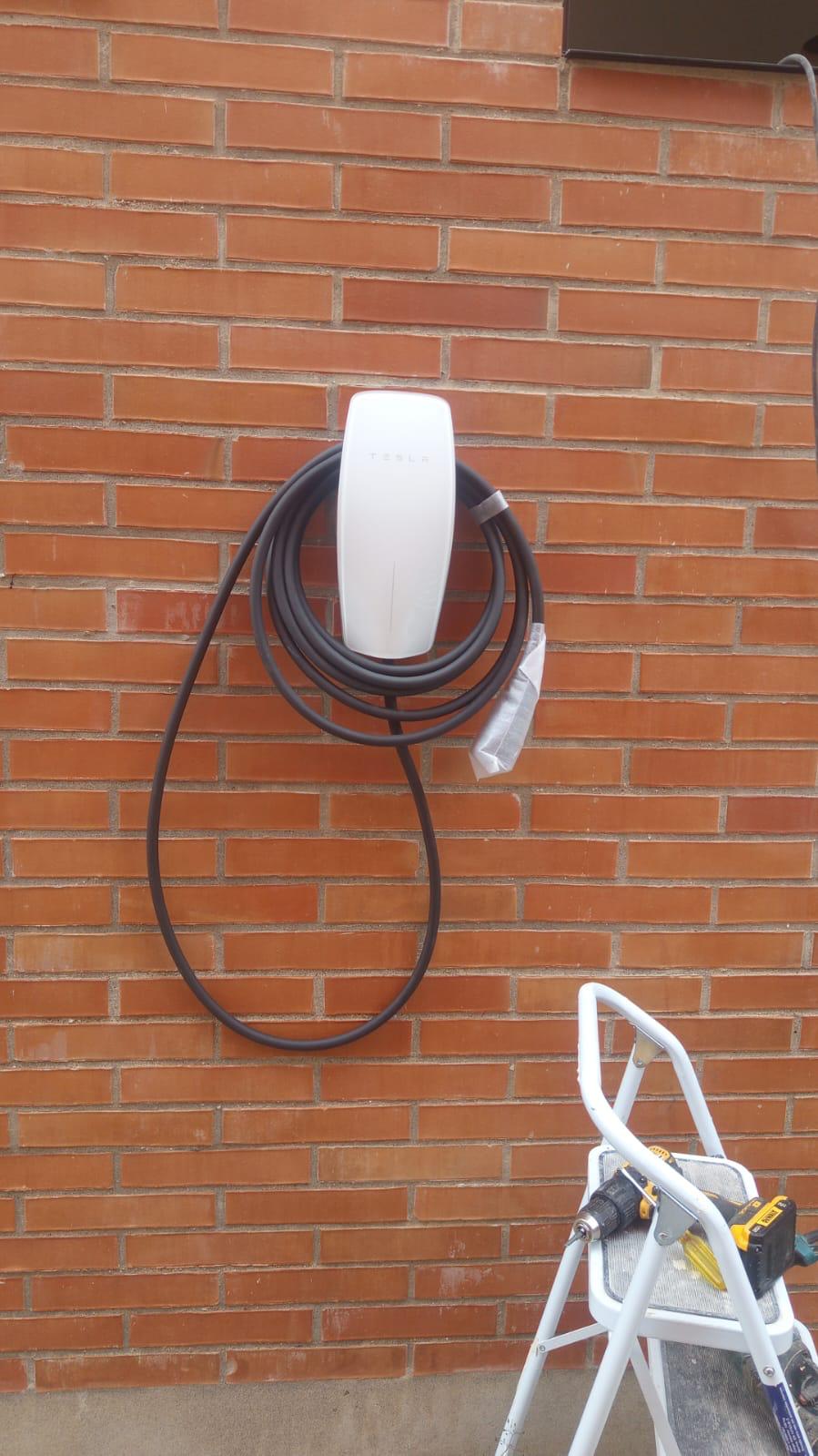 Cargador Tesla Wall Connector instalado por Ruta Eléctrica sobre fachada en ladrillo